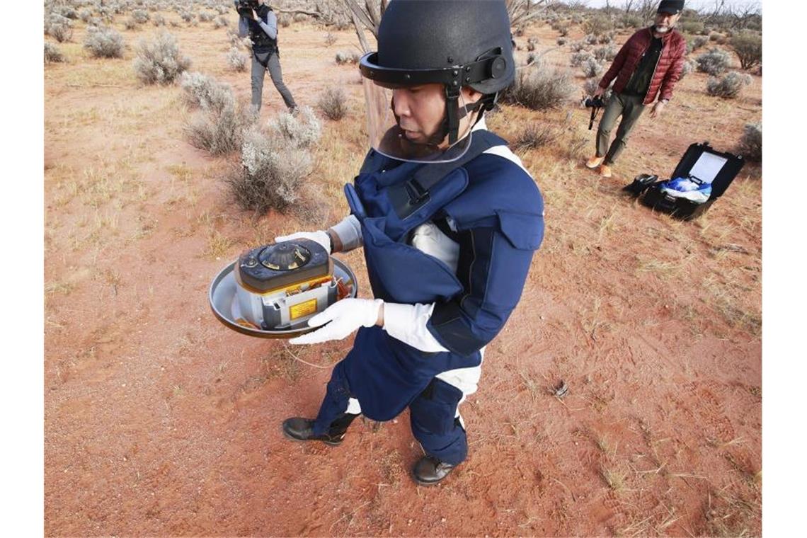 Große Erfolge bei Weltraum-Projekten von Japan und China Ein Wissenschaftler hält in der Wüste des Woomera-Testgeländes für Luft- und Raumfahrt im Süden Australiens die Probenkapsel der japanischen Raumsonde „Hayabusa2“. Foto: -/JAXA/AP/dpa