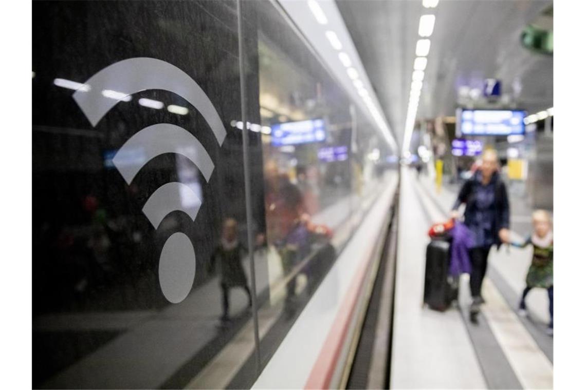 Ein WLAN-Logo auf der Fensterscheibe eines ICE weist darauf hin, dass in diesem Zug WLAN zur Verfügung steht. Foto: Christoph Soeder/dpa