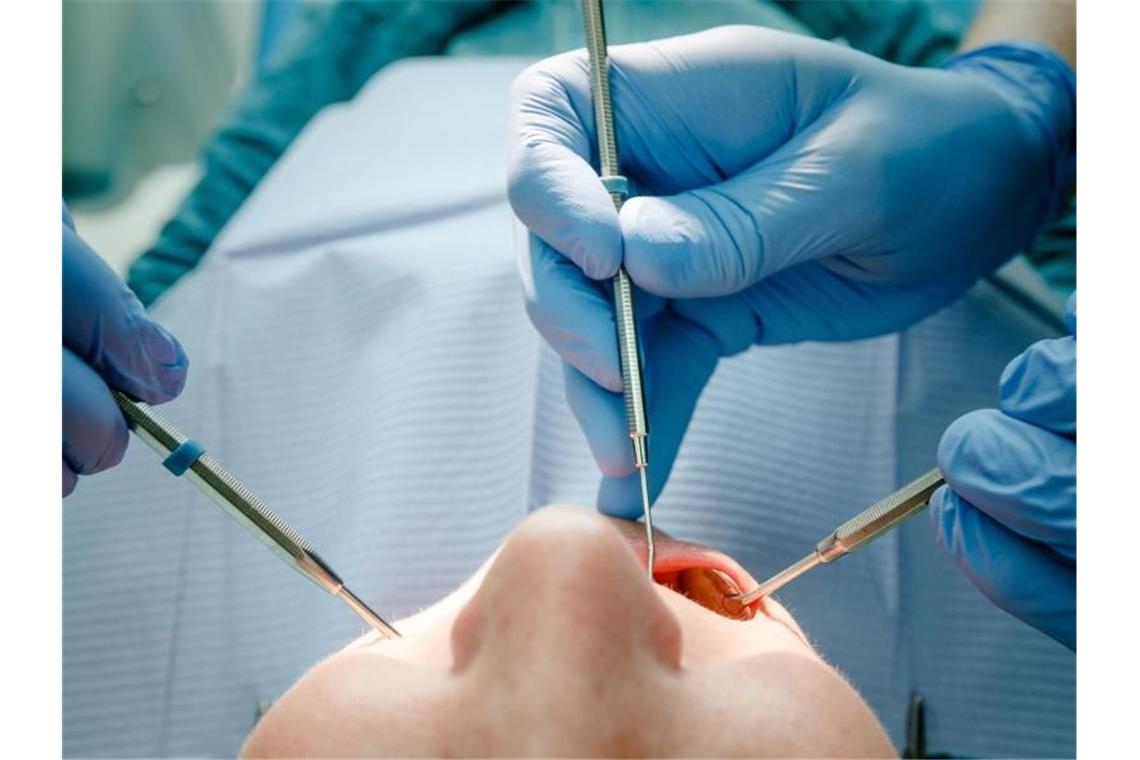 Zahnärzte: Bisher keine Corona-Infektionen in Südwest-Praxen Ein Zahnarzt behandelt einen Patienten. Foto: Markus Scholz/dpa/Symbolbild