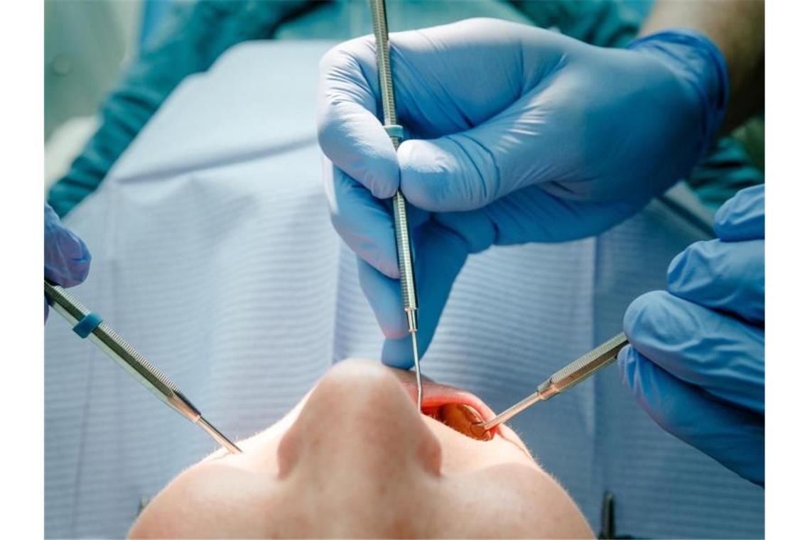 Zahnärzte: Einschränkungen immer wieder überprüfen Ein Zahnarzt behandelt einen Patienten. Foto: Markus Scholz/dpa/Illustration