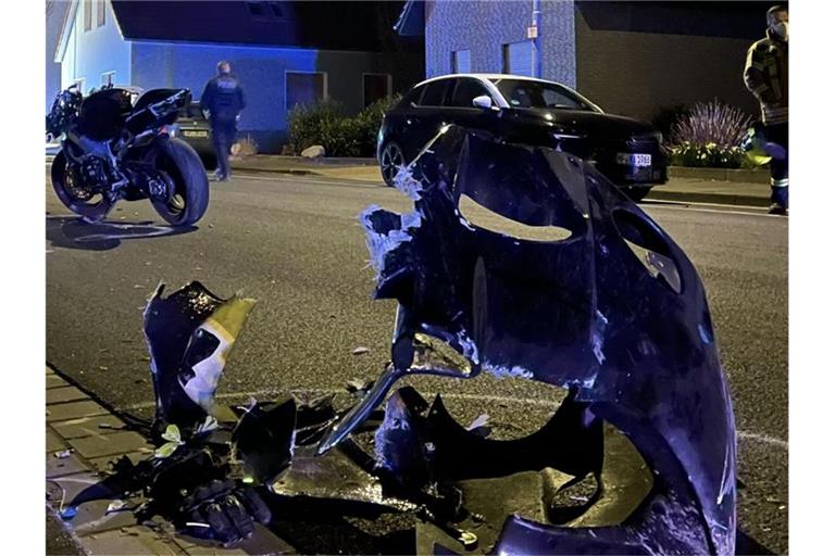 Ein zerstörtes Motorrad liegt in Hiddenhausen auf der Straße. Ein Anwohner wurde bei dem mutmaßlichen Rennen von zwei Motorrädern getötet. Foto: Christian Müller/Westfalennews/dpa