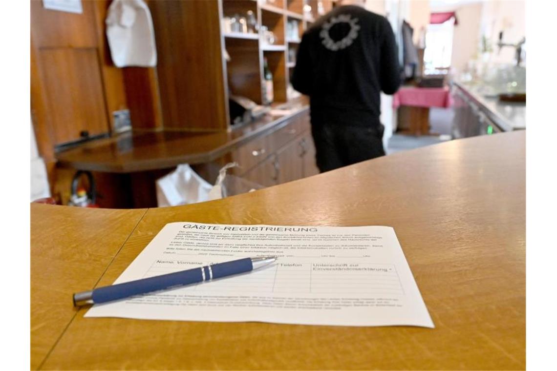 Neue Verordnung: Keine Mail-Adressen mehr in Kontaktlisten Ein Zettel für die Gäste-Regstrierung liegt in einem Restaurant auf einem Tisch. Foto: Carsten Rehder/dpa/Symbolbild