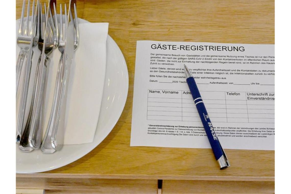 Ein Zettel für die Gäste-Regstrierung liegt in einem Restaurant auf einem Tisch. Foto: Carsten Rehder/dpa/Archivbild