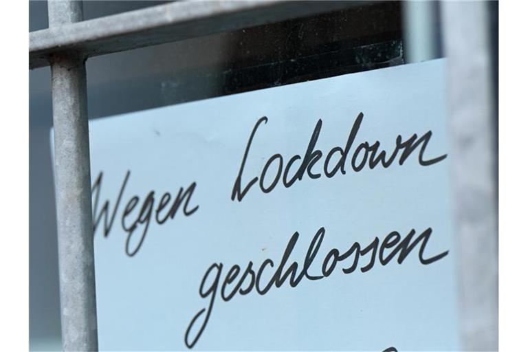 Ein Zettel mit der Aufschrift „Wegen Corona geschlossen“ hängt am Schaufenster eines Geschäfts in Seligenstadt. Foto: Arne Dedert/dpa