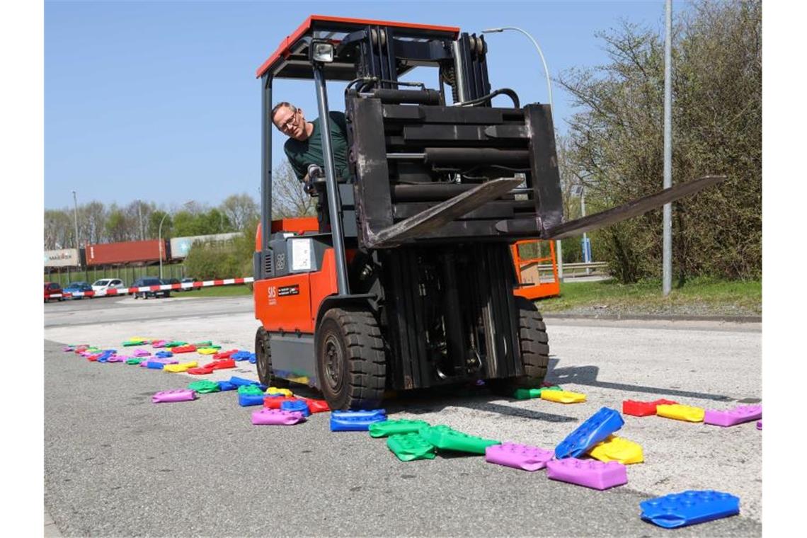 Ein Zollbeamter fährt in Bremerhaven mit einem Gabelstapler über gefälschte Legosteine, die vom Zoll beschlagnahmt worden sind, und zerstört sie. Foto: Mohssen Assanimoghaddam