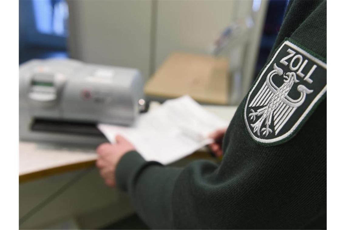Schweizer Einkaufstourismus: App kommt nicht voran Ein Zollbeamter stempelt einen Ausfuhrzettel ab. Foto: Felix Kästle/dpa