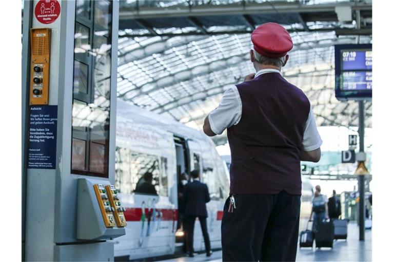 Ein Zugbegleiter gibt im Berliner Hauptbahnhof das Abfahrtszeichen für einen ICE. Foto: Carsten Koall/dpa
