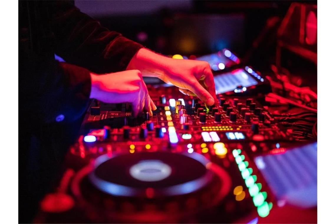 Illegale Silvesterparty mit rund 200 Personen aufgelöst Ein DJ steht auf einer Party am Mischpult. Foto: Matthias Balk/dpa/Symbolbild