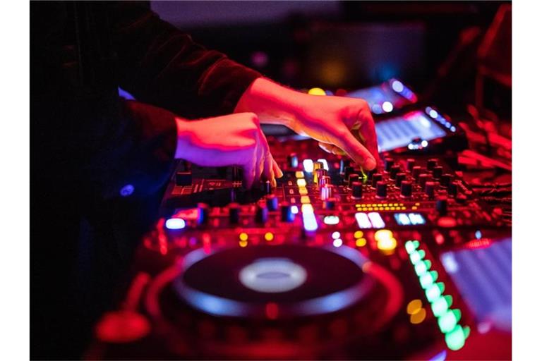 Ein DJ steht in einem Club am Mischpult. Foto: Matthias Balk/dpa/Symbolbild