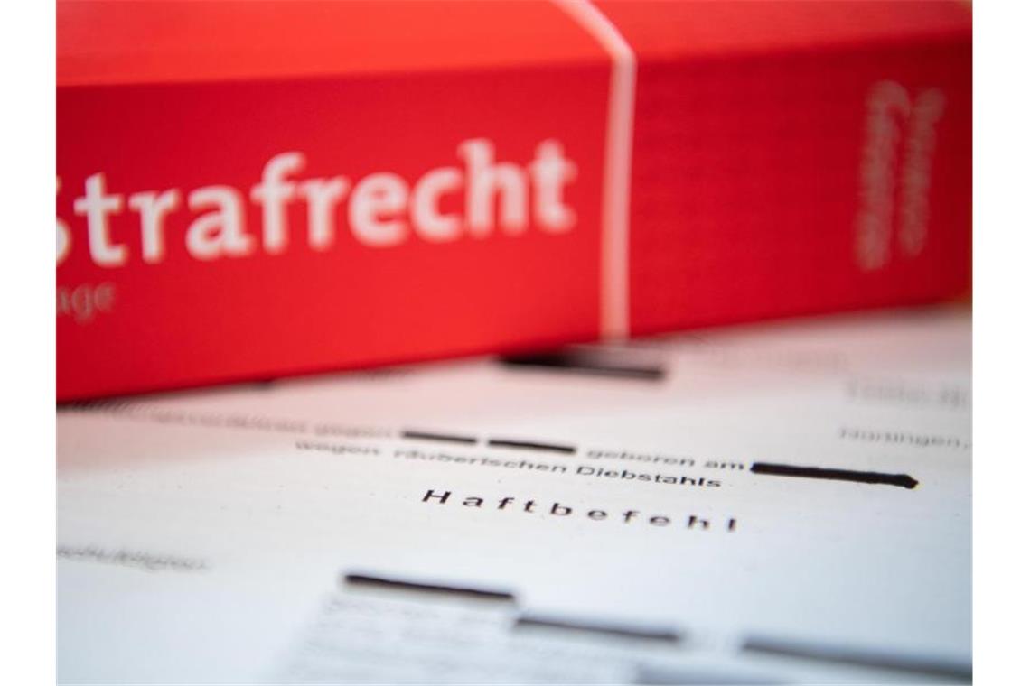 Haftbefehl gegen 22-Jährige nach Steinwürfen auf Fahrbahn Eine Abschrift eines Haftbefehls liegt mit einem Strafrecht-Buch auf dem Tisch. Foto: Tom Weller/dpa/Illustration