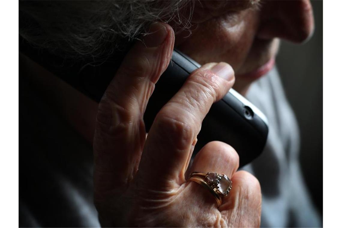 Telefonbetrüger erbeuten 50 000 Euro von Ehepaar Eine ältere Frau telefoniert mit einem schnurlosen Festnetztelefon. Foto: Karl-Josef Hildenbrand/dpa/Illustration