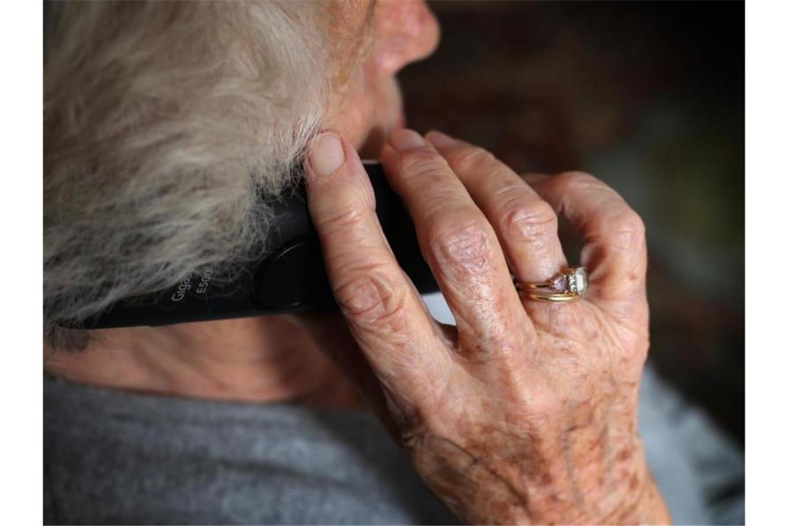 Eine ältere Frau telefoniert mit einem schnurlosen Festnetztelefon. Foto: Karl-Josef Hildenbrand/dpa/Symbolbild