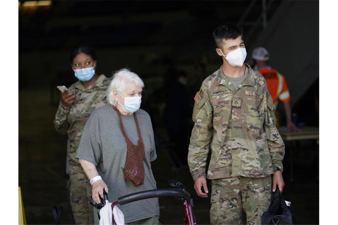 Hurrikan „Laura“ fegt über Teile der USA Eine ältere Frau wird in Lake Charles, Louisiana, während der Evakuierung von einem Soldaten begleitet. Foto: Gerald Herbert/AP/dpa