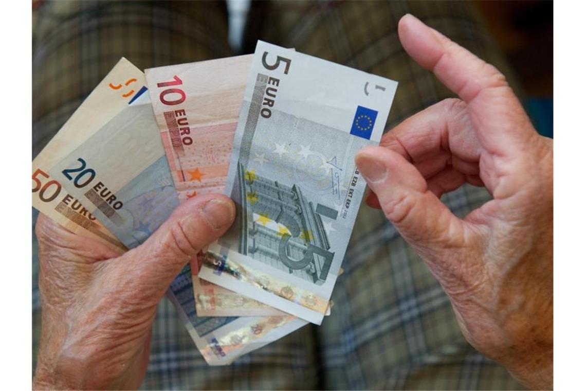 Eine ältere Frau zählt Geld. Foto: picture alliance / dpa