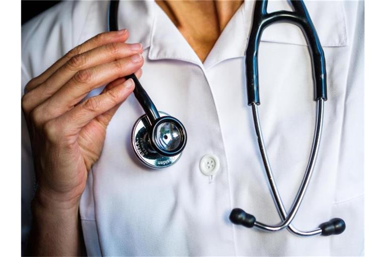 Eine Ärztin hält ein Stethoskop in den Händen. Von den insgesamt mehr als vier Millionen Erwerbstätigen in Gesundheits- und Pflegeberufen haben Ärzte die längsten Arbeitszeiten. Foto: Jens Büttner/zb/dpa