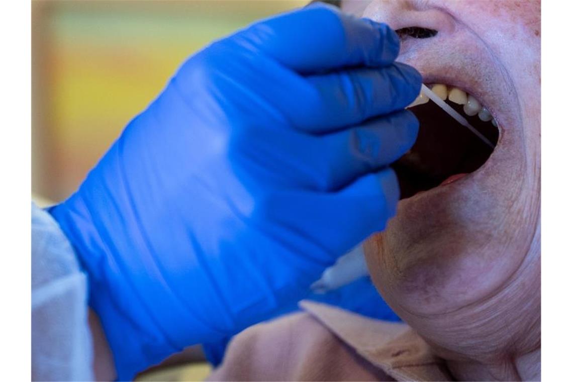 Tagesschwankungen, aber kein Rückgang bei Corona-Fällen Eine Altenpflegerin führt im Seniorenheim Pauline-Krone-Heim der Altenhilfe Tübingen einen Antigen-Corona-Schnelltest durch. Foto: Sebastian Gollnow/dpa