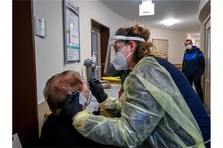 Eine Altenpflegerin testet am Eingang zum DRK-Pflege- und Betreuungszentrum "Tor zur Altstadt" in Sangerhausen eine Besucherin. Foto: Hendrik Schmidt/dpa-Zentralbild/dpa