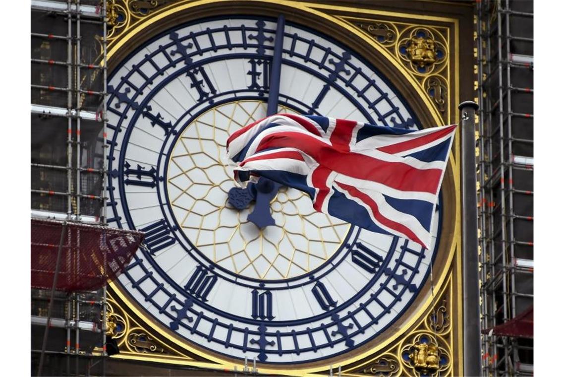 Eine am Ziffernblatt des Big Ben befestigte britische Flagge weht im Wind. Foto: Alberto Pezzali/AP/dpa