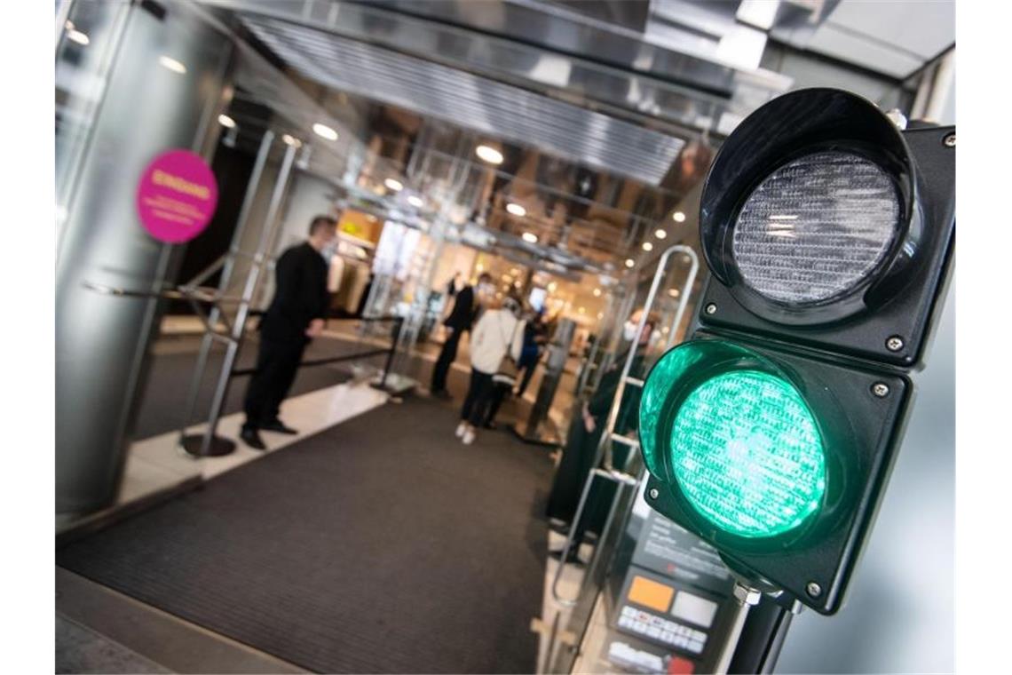 Handelsverband warnt Politik vor neuen Corona-Beschränkungen Eine Ampel regelt den Zutritt in ein Kaufhaus. Foto: Marijan Murat/dpa/Archivbild
