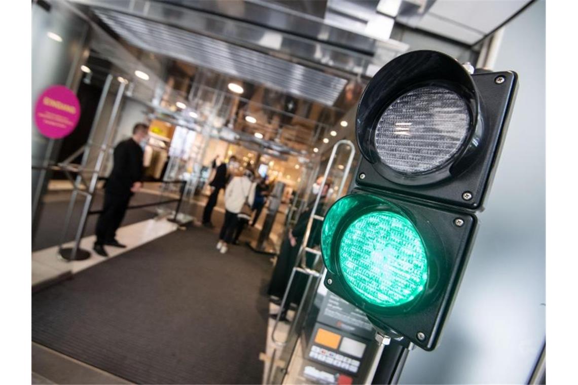 Eine Ampel regelt den Zutritt in ein Kaufhaus in Stuttgart. Der Groß- und Einzelhandel soll unter Auflagen zur Hygiene, zur Steuerung des Zutritts und zur Vermeidung von Warteschlangen insgesamt geöffnet bleiben. Foto: Marijan Murat/dpa