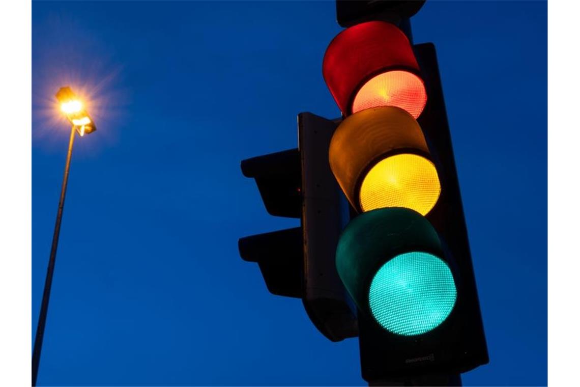 Eine Ampel zeigt am frühen Morgen die Farben rot, gelb und grün. Foto: Marijan Murat/dpa