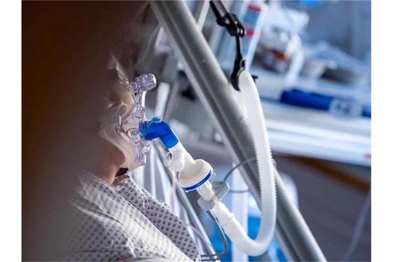 Eine an Covid-19 erkrankte Patientin wird in einem Zimmer des besonders geschützten Teils der Intensivstation des Universitätsklinikums Greifswald mit einer Maske beatmet. Foto: Jens Büttner/dpa-Zentralbild/dpa