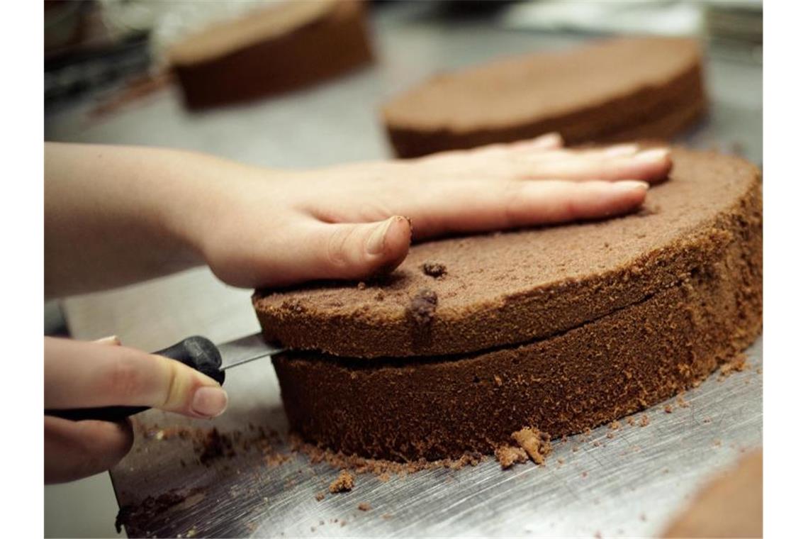 DGB fordert Umsetzung der Garantie für Ausbildungsplatz Eine angehende Konditorin schneidet einen Kuchenboden durch. Foto: picture alliance/dpa/Symbolbild