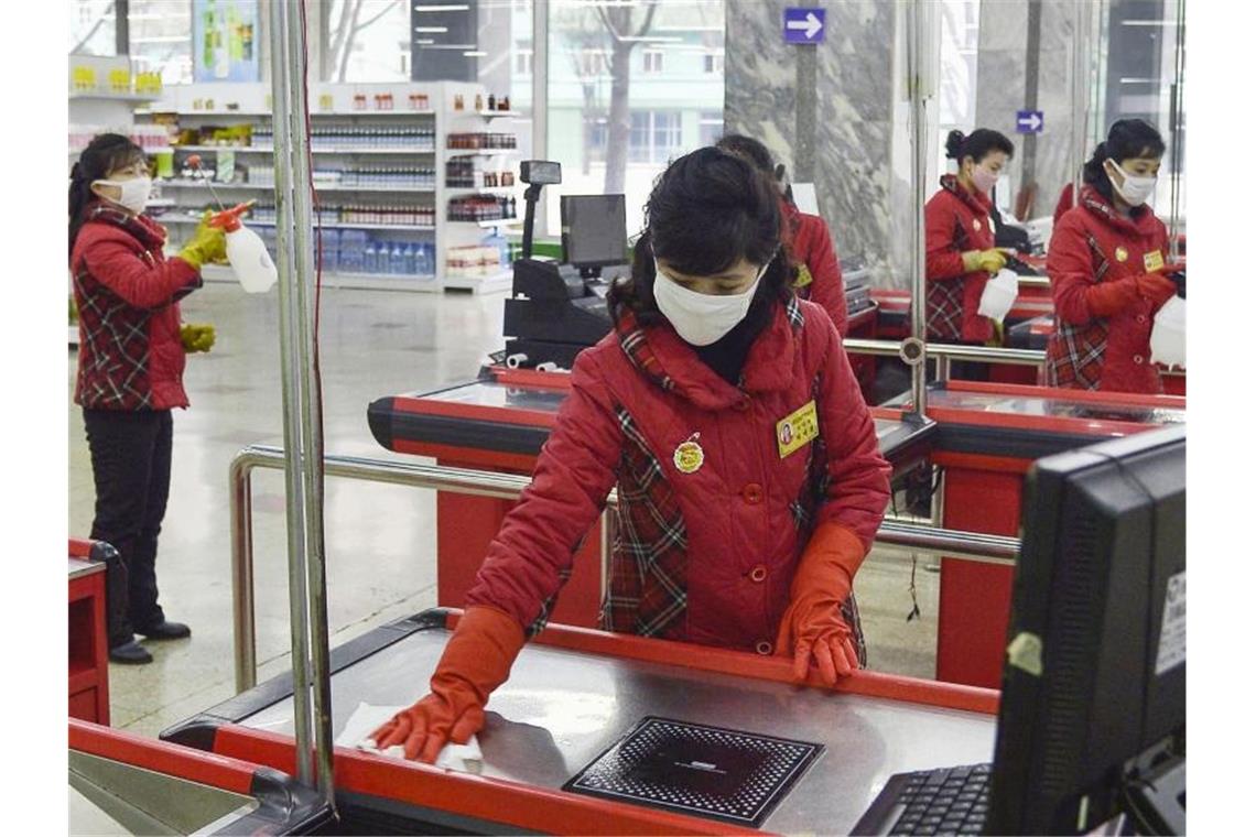 Eine Angestellte desinfiziert in einem Kaufhaus in der nordkoreanischen Hauptstadt Pjöngjang eine Kasse. Foto: Uncredited/Kyodo News/AP/dpa