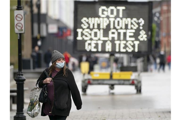 Eine Anzeigetafel erinnert in Großbritannien an das richtige Vehalten beim Auftreten von Corona-Symptomen. Foto: XinHua/dpa
