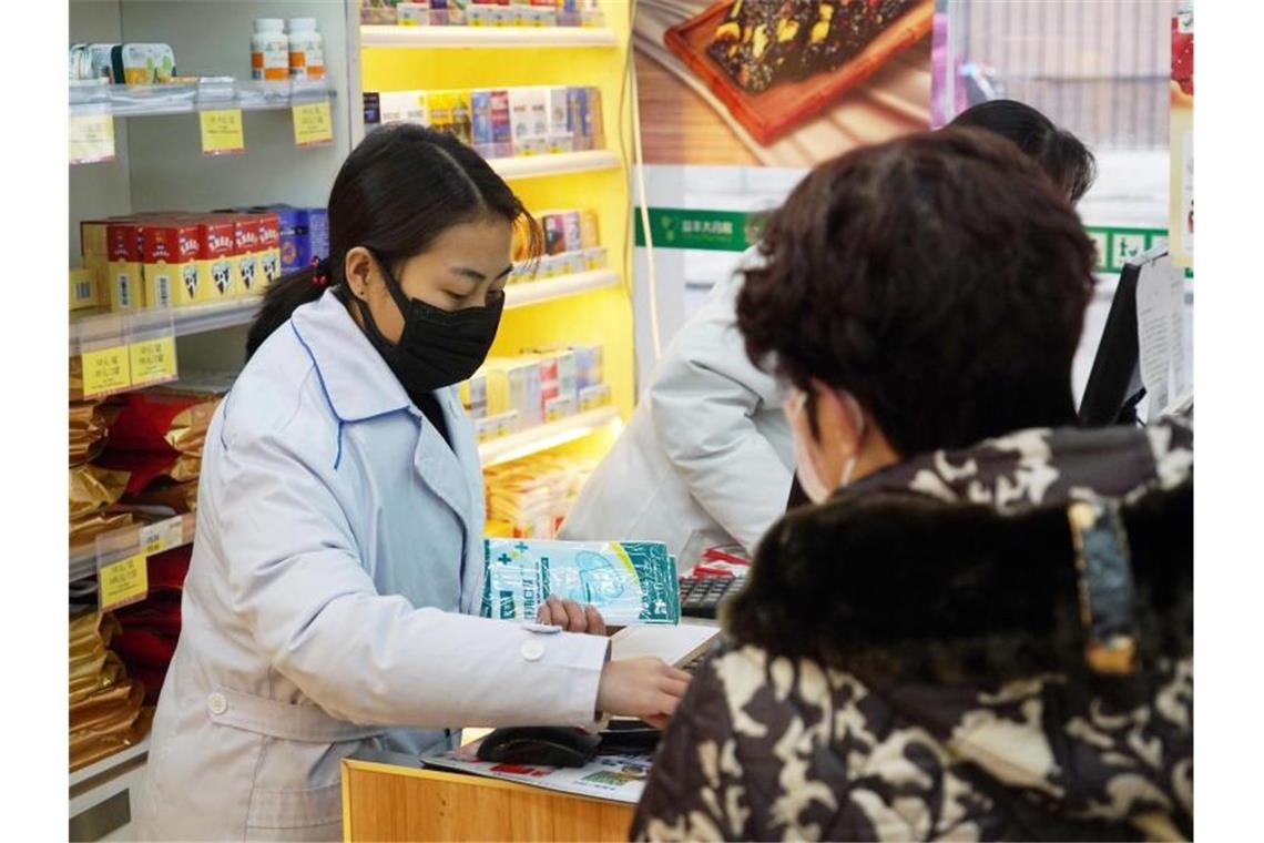 Eine Apothekerin verkauft in Wuhan Atemschutzmasken. Die chinesische Stadt gilt als Ausgangspunkt der neuartigen Lungenkrankheit. Foto: Dake Kang/AP/dpa