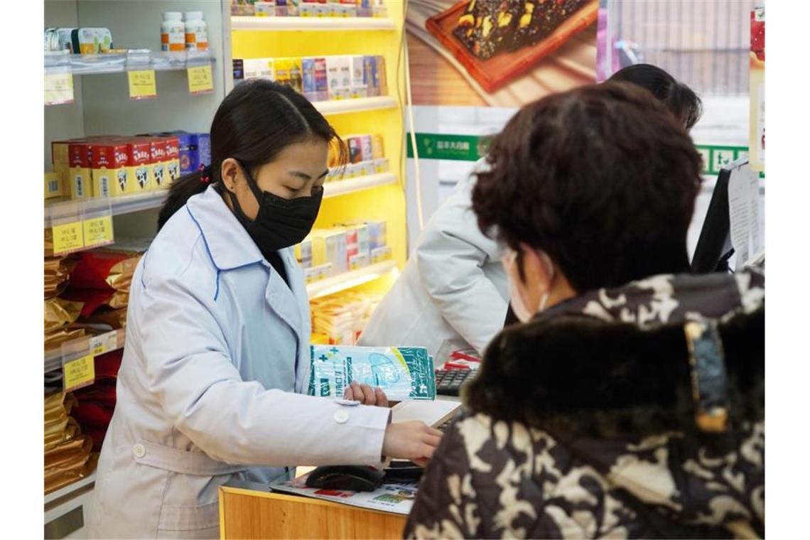 Einwohner sollen Wuhan ohne wichtigen Grund nicht verlassen Eine Apothekerin verkauft in Wuhan Atemschutzmasken. Die chinesische Stadt gilt als Ausgangspunkt der neuartigen Lungenkrankheit. Foto: Dake Kang/AP/dpa