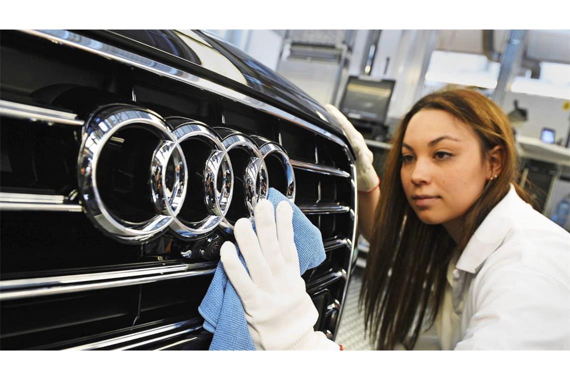 Eine Audi-Mitarbeiterin poliert in Neckarsulm die Audi-Ringe an einer A8-Limousine. Die Zukunft des Werks ist gefärhdet.