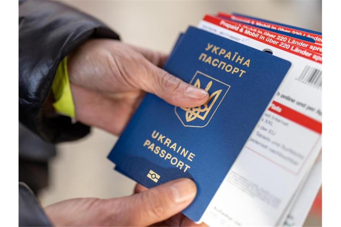 Immer mehr Menschen fliehen aus der Ukraine Eine aus der Ukraine geflüchtete Frau hält bei ihrer Ankunft am Münchner Hauptbahnhof ihren Reisepass in den Händen. Foto: Daniel Karmann/dpa