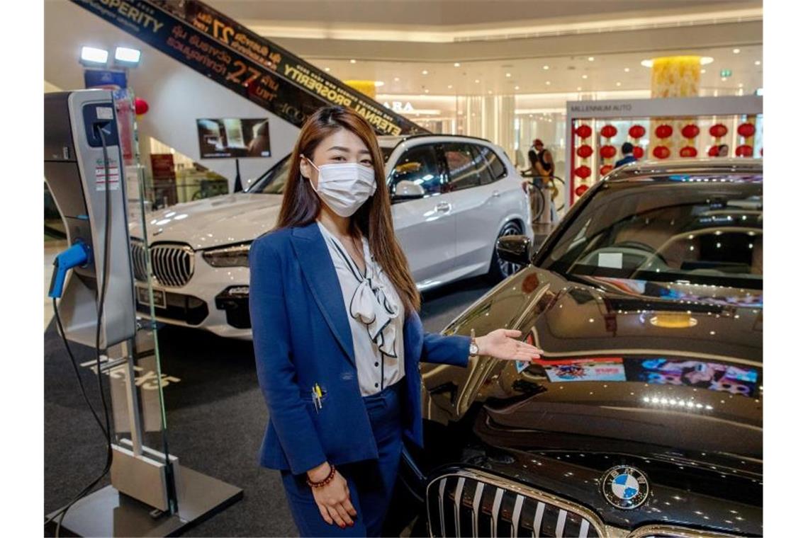 Vier Coronavirusfälle in Deutschland Eine Autoverkäuferin in Thailands Hauptstadt Bangkok trägt eine Schutzmaske. Foto: Gemunu Amarasinghe/AP/dpa