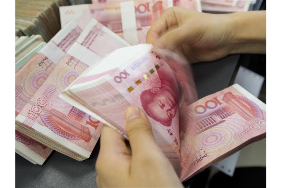 China stemmt sich gegen Yuan-Aufwertung Eine Bankangestellte zählt ein Bündel Geldscheine. Die chinesische Notenbank hat Maßnahmen gegen die Stärke der heimischen Währung Yuan ergriffen. Foto: Xu Jingbo/SIPA Asia via ZUMA Wire/dpa
