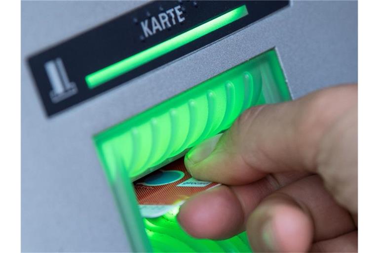 Eine Bankkundin steckt ihre Girokarte in einen Geldautomaten. Foto: Fabian Sommer/dpa/Symbolbild/Archiv