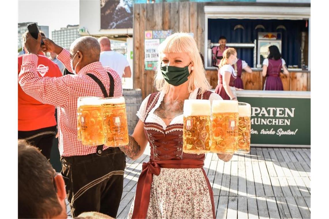 Sorge um Mini-Wasen in Stuttgarter Restaurants wegen Corona Eine Bedienung trägt Biergläser bei einer Festveranstaltung mit dem Titel „Wiesn da oben“. Foto: Ferdinando Iannone/dpa/Archivbild