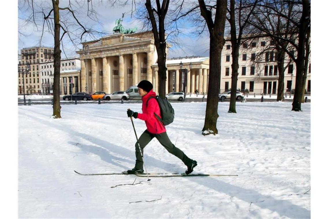 Mindestens bis zum Wochenende bleibt es kalt Eine Berlinerin passiert mit Langlaufskiern das Brandenburger Tor in Berlin. Foto: Wolfgang Kumm/dpa