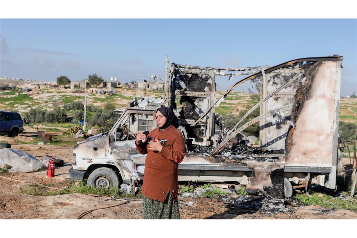 Eine Bewohnerin steht neben einem ausgebrannten Fahrzeug im Dorf Susya bei Hebron im besetzten Westjordanland. Israelische Siedler sollen Ende Februar dort Zelte und Autos angezündet haben.