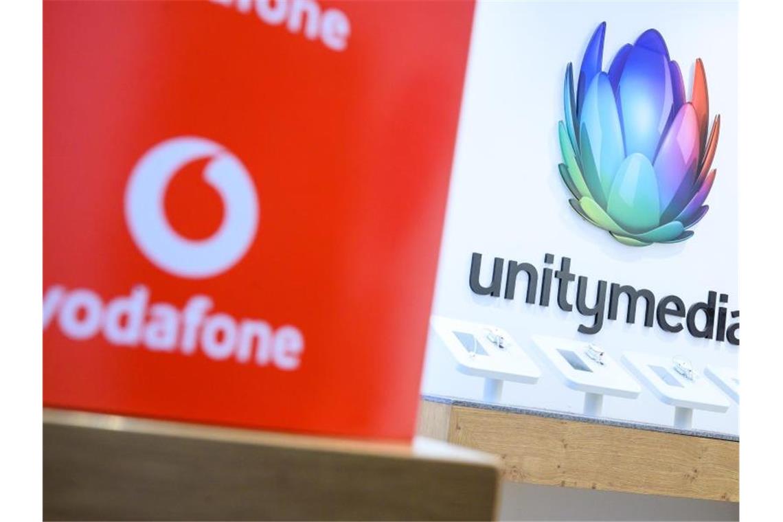 Eine Box mit dem Logo von Vodafone steht in einem Shop des Unternehmens vor einem Logo von Unitymedia. Foto: Sebastian Gollnow/dpa