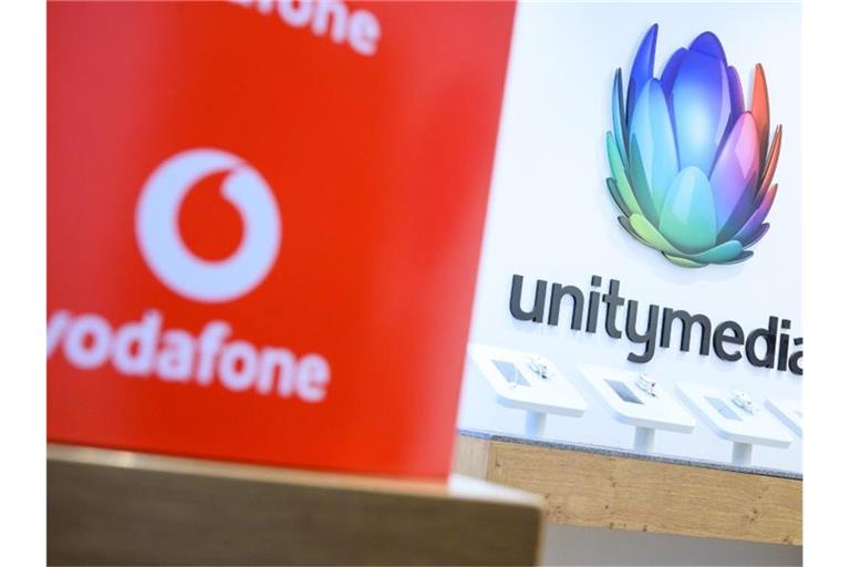 Eine Box mit dem Logo von Vodafone steht in einem Shop des Unternehmens vor einem Logo von Unitymedia. Foto: Sebastian Gollnow/dpa