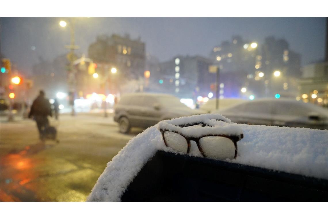Eine Brille liegt während eines Schneesturms in New York im Schnee auf einem Briefkasten.
