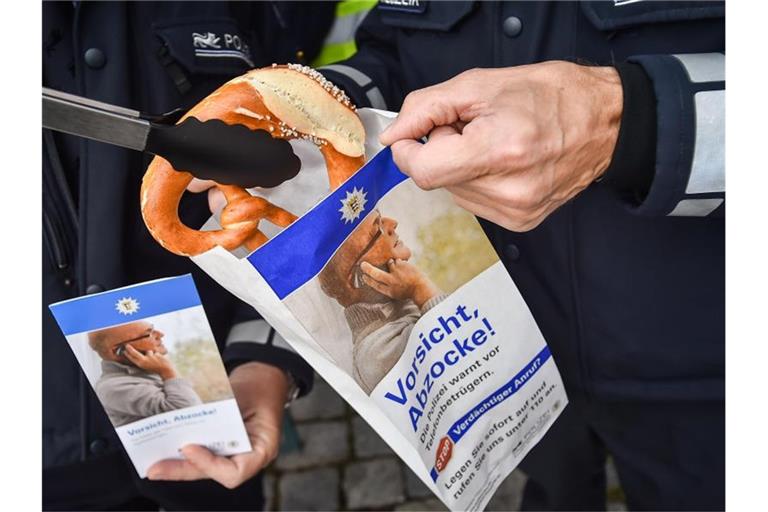 Eine Brötchentüte mit der Aufschrift „Vorsicht Abzocke! Die Polizei warnt vor Telefonbetrügern.“. Foto: Ferdinando Iannone/dpa