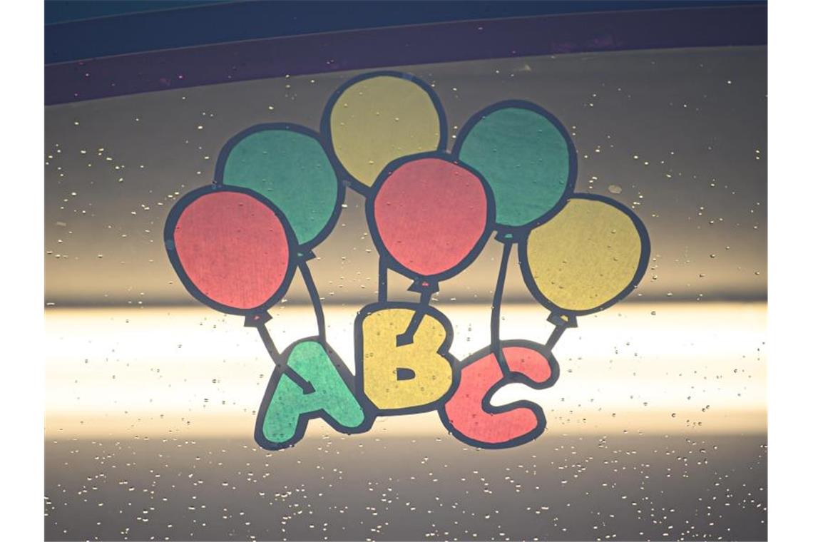 Eine bunte Zeichnung mit den Buchstaben "ABC" und Luftballons klebt zu Beginn des neuen Schuljahrs an einem Fenster. Foto: Robert Michael/dpa-Zentralbild/dpa/Aktuell