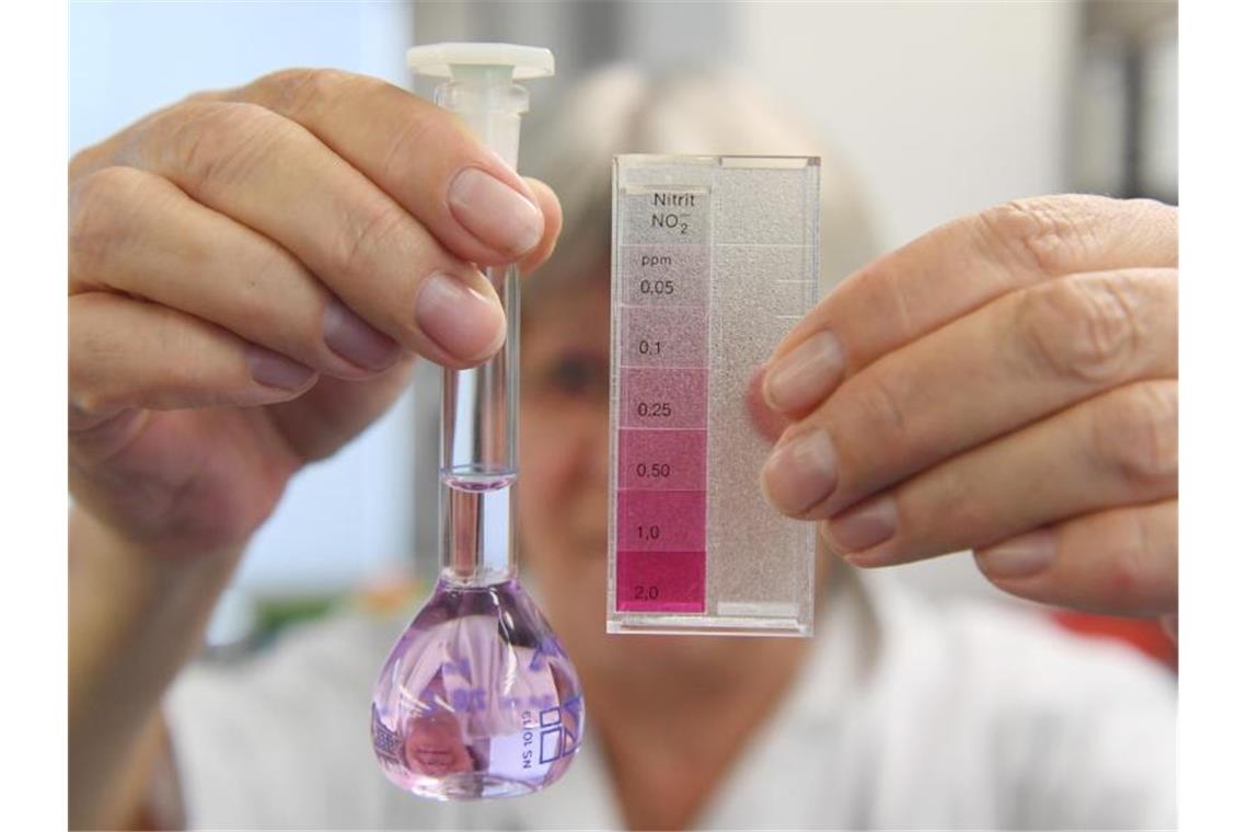 Eine Chemielaborantin zeigt ein Flasche mit einer Grundwasserprobe zur Nitratüberprüfung. Foto: Uli Deck/dpa/Archivbild