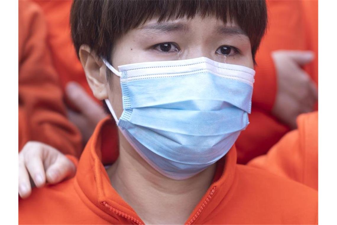 Eine chinesische Ärztin mit Mundschutzmaske hat Tränen in den Augen. Foto: Cai Yang/XinHua/dpa