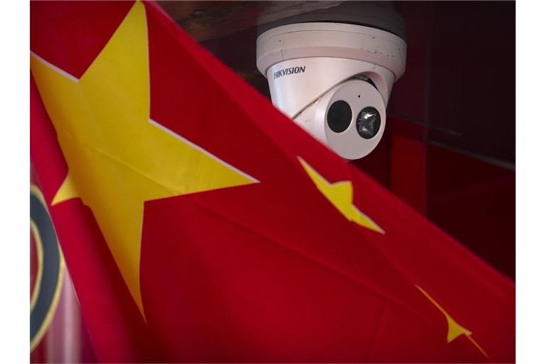 Eine chinesische Flagge weht neben einer Sicherheitskamera der Firma Hikvision in Peking. Foto: Mark Schiefelbein/AP/dpa