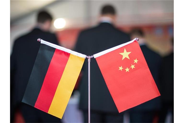 Eine chinesische und eine deutsche Flagge stehen am bei einem Empfang im chinesischen Hefei (China). Foto: picture alliance/Ole Spata/dpa