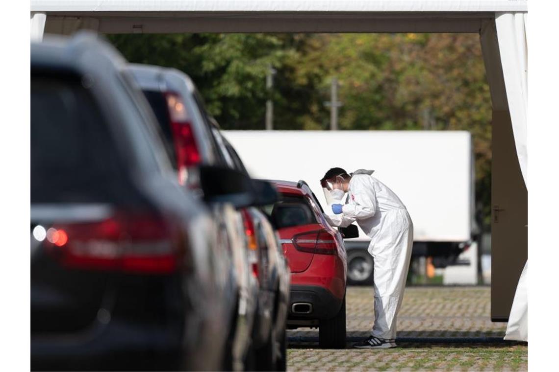 Corona-Infektionen in Stuttgart - Warnstufe überschritten Eine Corona-Abstrichstelle in Stuttgart. Die Stadt hat die wichtige Warnstufe von 50 Neuinfektionen pro 100.000 Einwohner in sieben Tagen überschritten. Foto: Marijan Murat/dpa