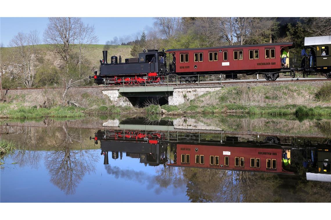 Eine Dampflokomotive ist auf der Schwäbischen Alb unterwegs und spiegelt sich in einem Gewässer.